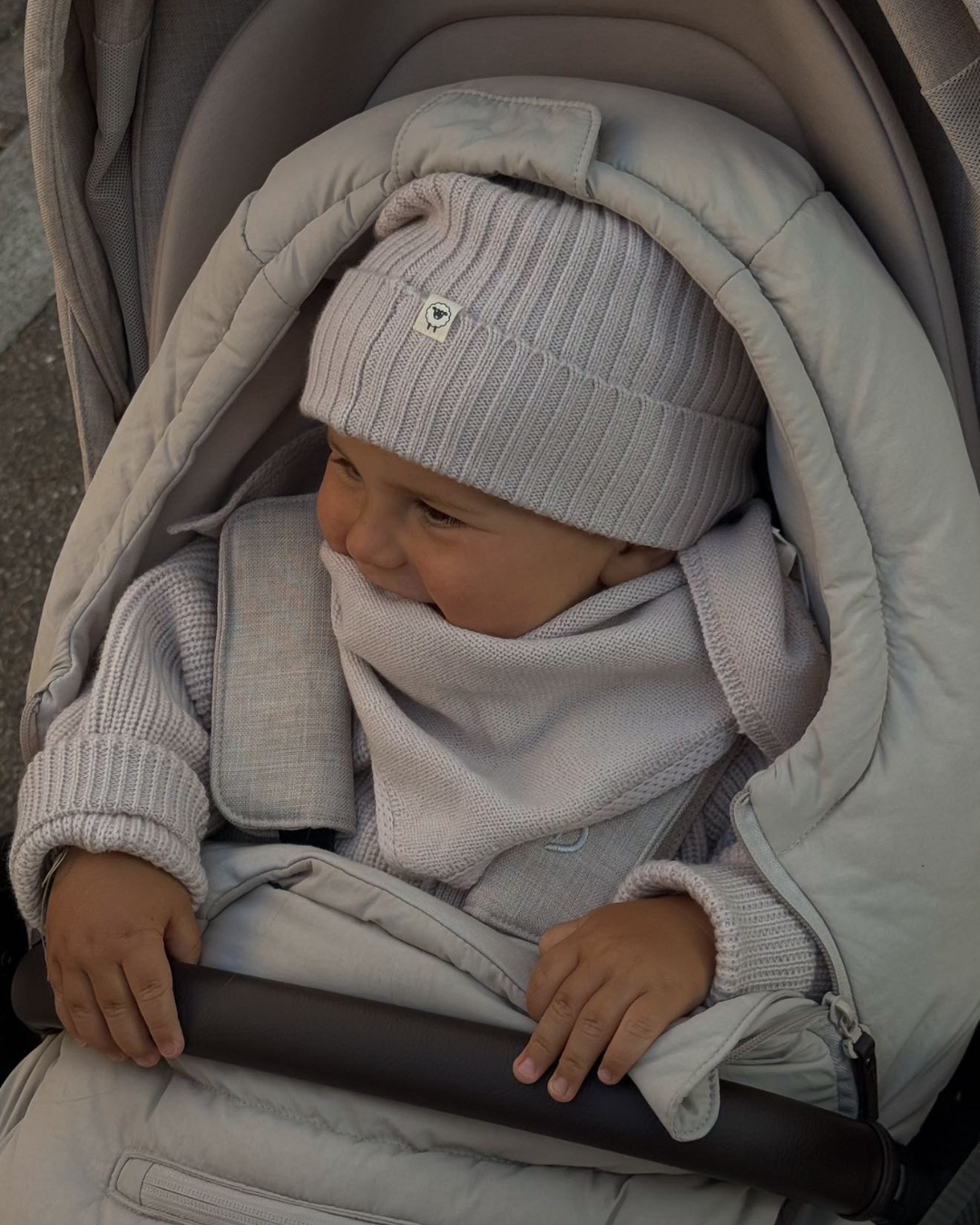 Baby mit Mütze Emma aus Merinowolle